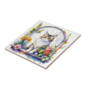 Zoete grillige kat in venster van bloemen tegeltje (Zijkant)