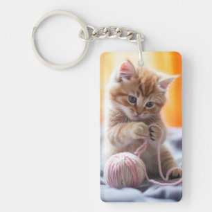 Zoete oranje kitten speelt met garen sleutelhanger
