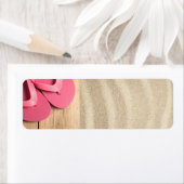 Zomerconcept met roze Teenslippers op zandstrand Etiket (Insitu)