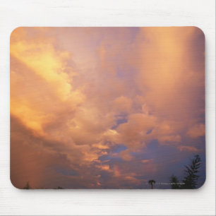 Zon die achter wolken plaatst muismat