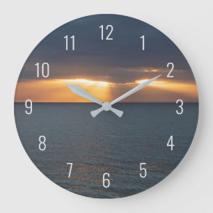 Zon over de oceaan die door de wolken breekt grote klok