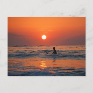 Zon over de oceaan met een surfer in het water briefkaart