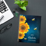 Zonnebloemen gele bijen blauwe lucht naam planner<br><div class="desc">Maak je klaar om je dagen te organiseren met een vleugje natuurlijke charme met onze gepersonaliseerde zonnebloem en bijenspiraalplanner. Deze prachtige planner heeft een serene donkerblauwe hemelachtergrond versierd met levendige watergekleurde zonnebloemen en vrolijke lachende bijen, die een gevoel van vreugde en grilligheid in uw dagelijkse planning brengen. Serene Donkerblauwe Hemel...</div>