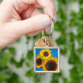Zonnebloemen tegen blauwe omheining sleutelhanger (Hand)