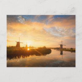 Zonneopstand boven windmolens en een rivier in Ned Briefkaart