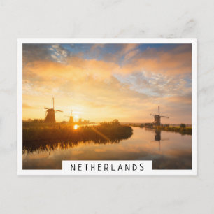 Zonneopstand boven windmolens en een rivier in Ned Briefkaart