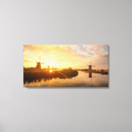 Zonneopstand boven windmolens en een rivier in Ned Canvas Afdruk