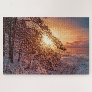 Zonnesten boven zee en snowy-pijnboompuzzel legpuzzel