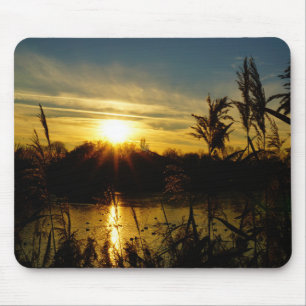 Zonsondergang bij een meertje met rietpluimen. muismat