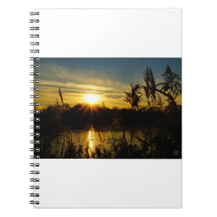 Zonsondergang bij een meertje met rietpluimen. notitieboek