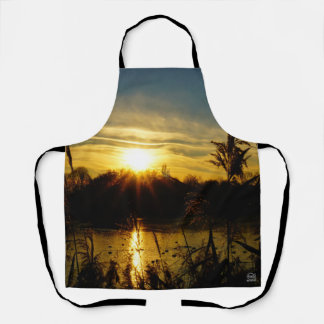 Zonsondergang bij een meertje met rietpluimen. schort