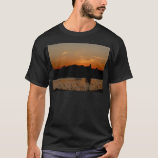 Zonsondergang over een nachtelijk rivierlandschap. t-shirt