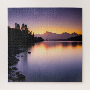 Zonsondergang reflecterend over een meer legpuzzel