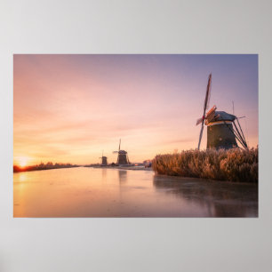 Zonsopgang boven bevroren rivier met windmolens en poster