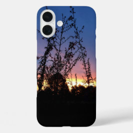 Zonsopgang tussen silhouet van wilde bloemstengels iPhone 16 plus hoesje