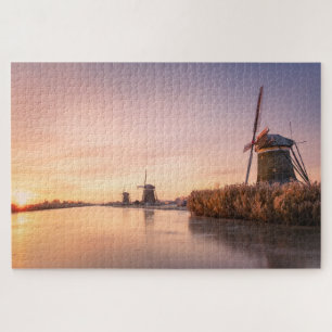 Zonsopkomst over bevroren rivier met windmolens en legpuzzel