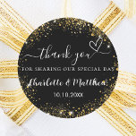 Zwart gouden hart bruiloft dank u ronde sticker<br><div class="desc">Een stijlvolle zwarte achtergrond versierd met faux gouden glitter,  schittert. Personaliseer en voeg uw namen en trouwdatum toe. Met de tekst: Bedankt voor het delen van onze speciale dag.</div>