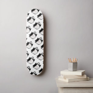 Zwart katje met rode neus verstopt in een kopje persoonlijk skateboard