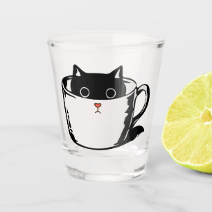 Zwart katje met rode neus verstopt in een kopje shot glas