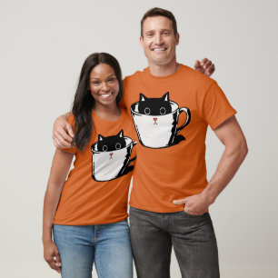 Zwart katje met rode neus verstopt in een kopje t-shirt