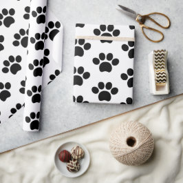 Zwart-kattehondenpootje drukt schattig op wit cadeaupapier