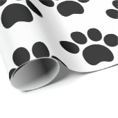 Zwart-kattehondenpootje drukt schattig op wit cadeaupapier (Rol Hoek)