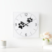 Zwart kattenpootje drukt wit af vierkante klok (Huis)