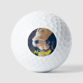 Zwart-wit Bernedoodle hond in geel golf pet. Golfballen