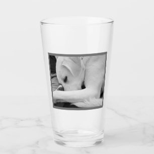 Zwart-wit foto van Schattigee hond rusten met papa Glas