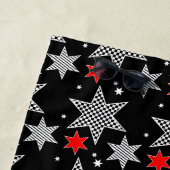 Zwart wit gecheckte strips en rode sterren op zwar strandlaken (In situ)