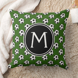 Zwart-witte voetballen op een groen monogram kussen