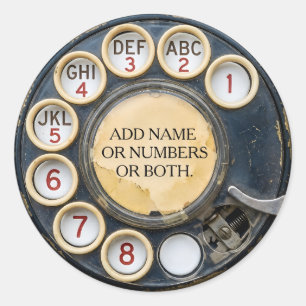 Zwarte antieke draaischijftelefoon met distressed ronde sticker