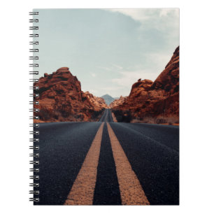 ZWARTE ASPHALT ROAD TUSSEN BROWN ROCK FORMATIE VN NOTITIEBOEK