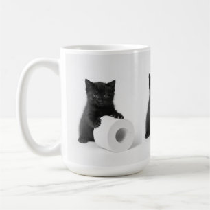 Zwarte babykat beschermt rol toiletpapier koffiemok