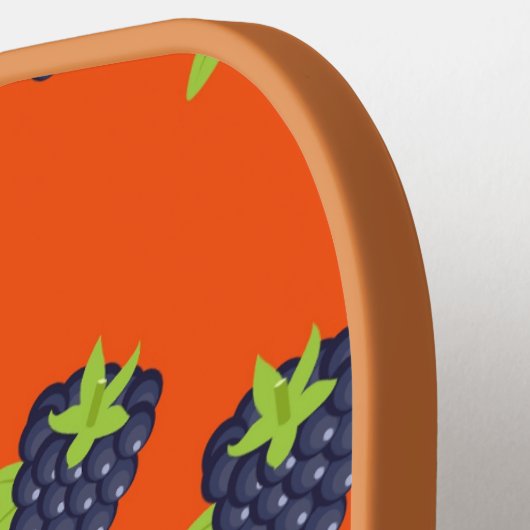 Zwarte bessen op sinaasappel pickleball paddle (Links Detail)