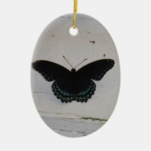 Zwarte en blauwe vlinder op wit gewassen hout keramisch ornament