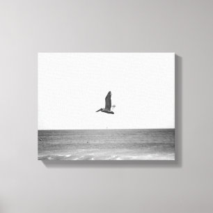 Zwarte en witte bruine pelikaan die over de oceaan canvas afdruk