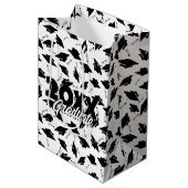 Zwarte gradatiekappen getoseerd in de lucht op wit medium cadeauzakje (Voorkant Gekanteld)