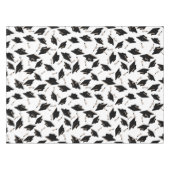 Zwarte gradatiekappen getoseerd in de lucht op wit tafelkleed (Voorkant (Horizontaal))