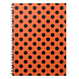 Zwarte haarpunten op oranje notitieboek