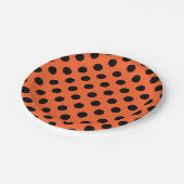 Zwarte haarpunten op oranje papieren bordje (Gekanteld)