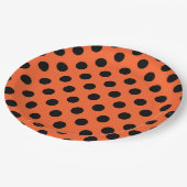 Zwarte haarpunten op oranje papieren bordje (Gekanteld)
