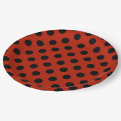 Zwarte haarpunten op rood papieren bordje (Gekanteld)