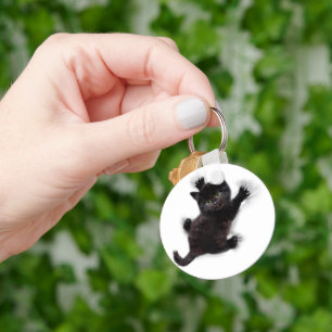 Zwarte kat klimmen op menselijke rug sleutelhanger