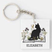 Zwarte kat met bloemenboek sleutelhanger (voorkant)