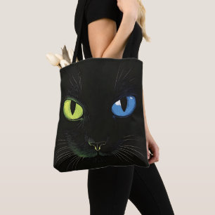 Zwarte kat met groene en blauwe ogen tote bag