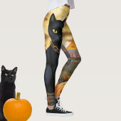 Zwarte kat onder een oogstmaan en pompoenen leggings
