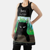 Zwarte kat op hek met groen gras schort (Insitu)