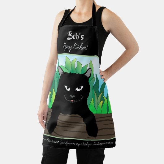 Zwarte kat op hek met groen gras schort (Insitu)