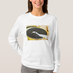 Zwarte kaviaar en een lepel van parelmoer om t-shirt